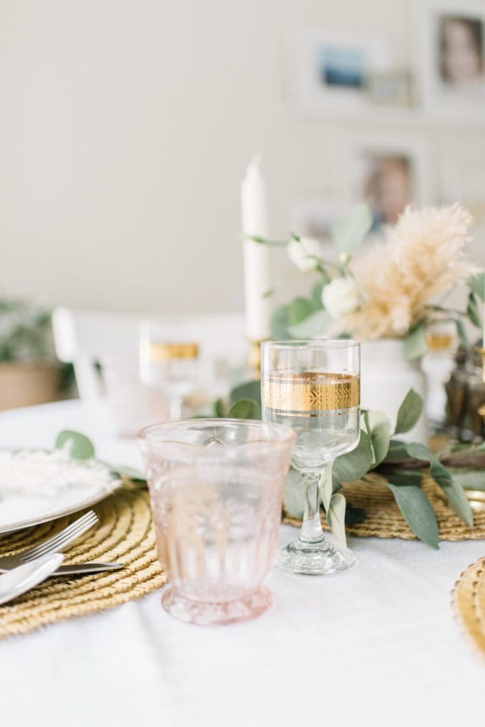 A vase of flowers on a table with gold filigree glasses