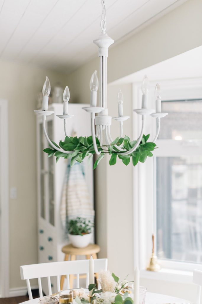 white chandelier with draped greenery