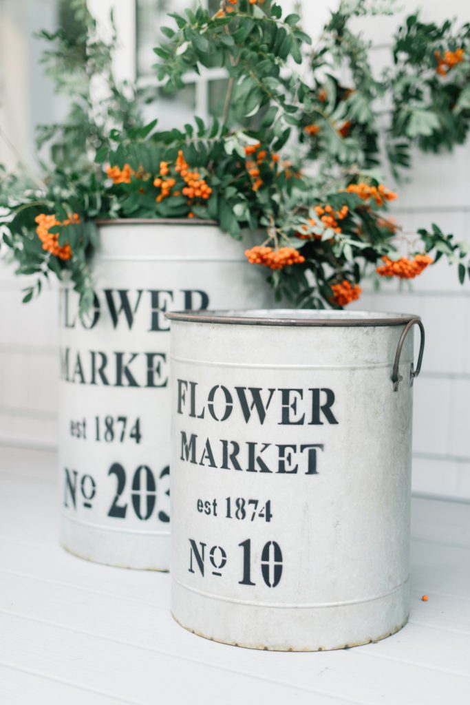Foraged berry branches in galvanized tubs are a simple way to decorate the front porch for fall