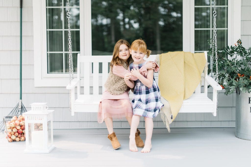 2 girls on a porch swing