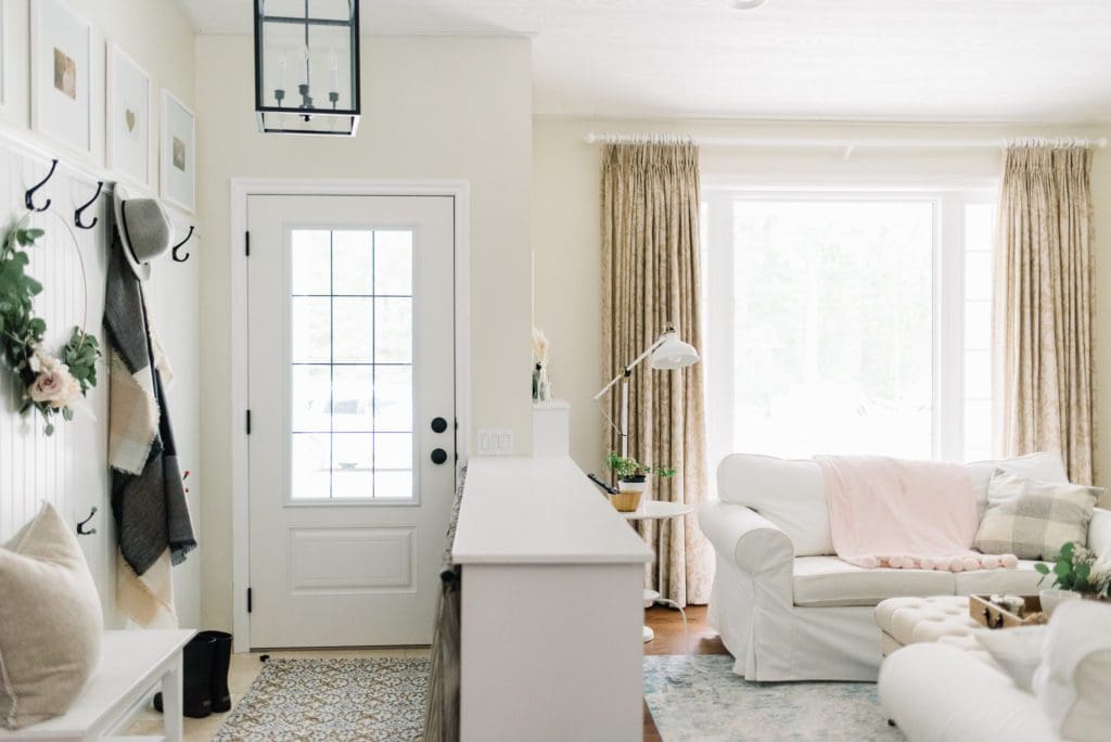 small entryway delineated by a half wall separating the entryway from the living room