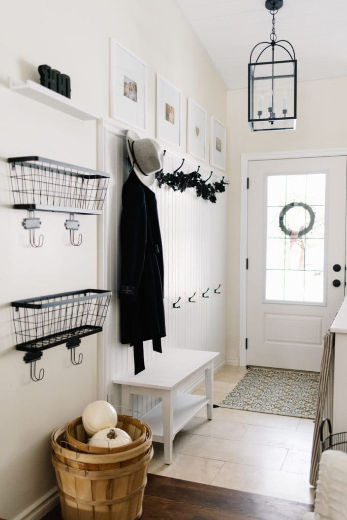 Black garland and white pumpkins make this entrance Halloween ready