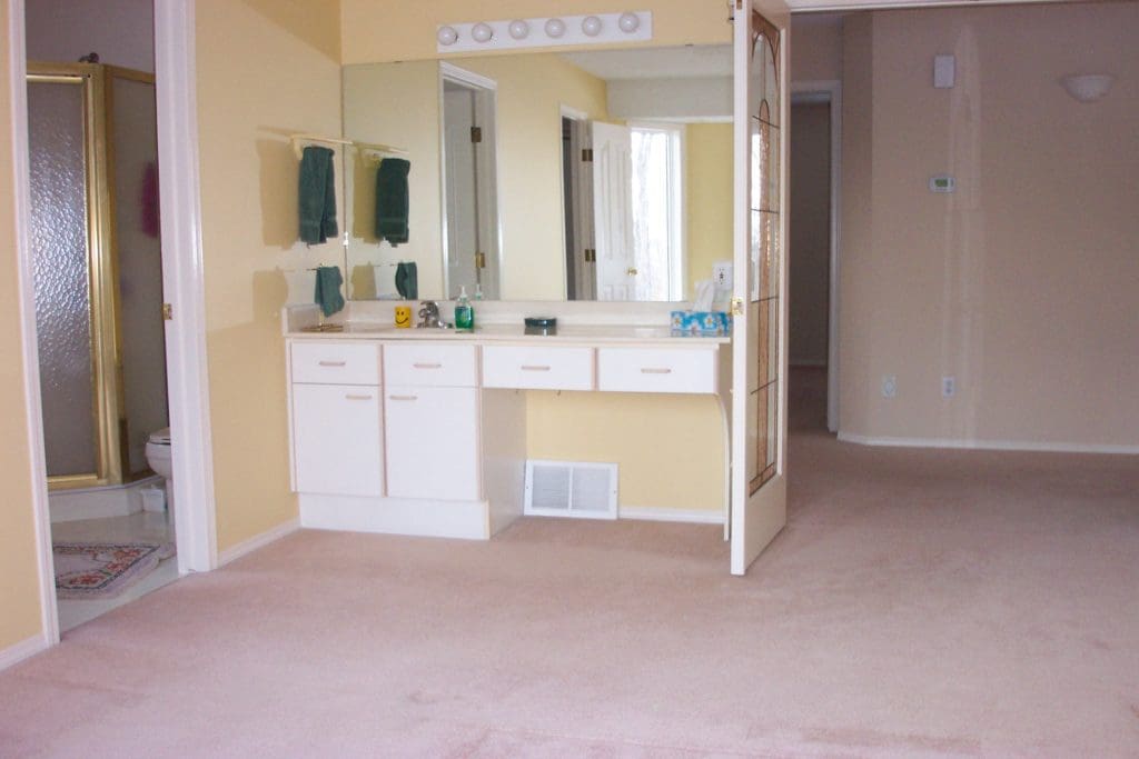 master bedroom before renovation with sink in bedroom and yellow walls