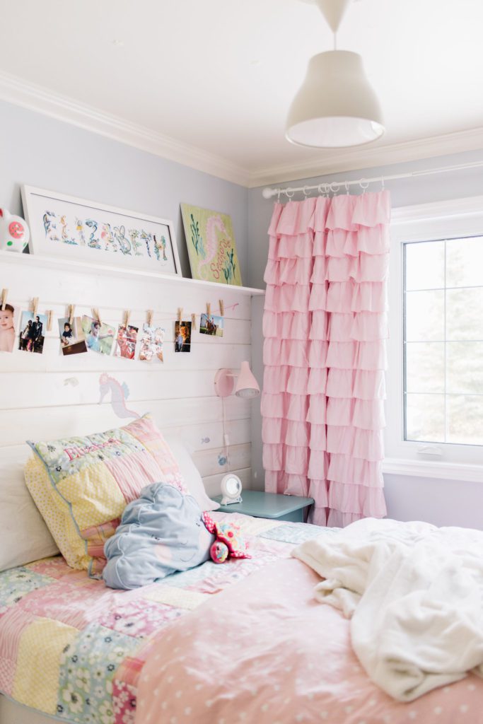 A small bedroom is cheerful with bright colours and functional shelving