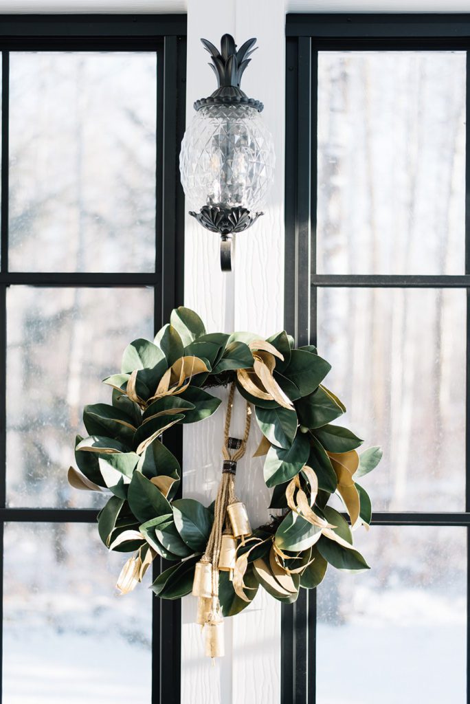 Magnolia wreath and bells from McGee & Co. add a festive touch to this outdoor room at The Ginger Home!