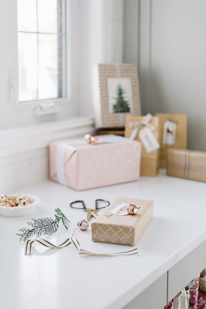 wrapped presents sit on a counter beside scissors and ribbon