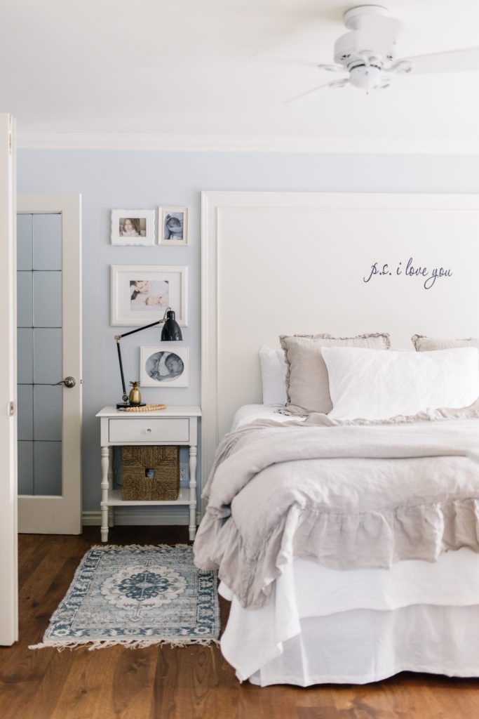 Bedside tables with drawers and baskets maximize storage in this small master bedroom