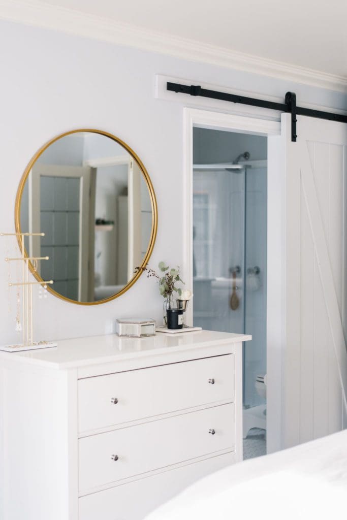 A dresser and sliding barn door add storage and save space in a small master bedroom.