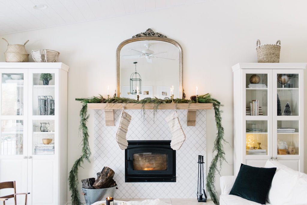 Simple Christmas mantle styling with cedar garland and vintage brass candlesticks