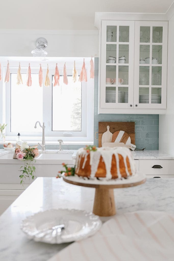 A cake on a pedestal on a kitchen island