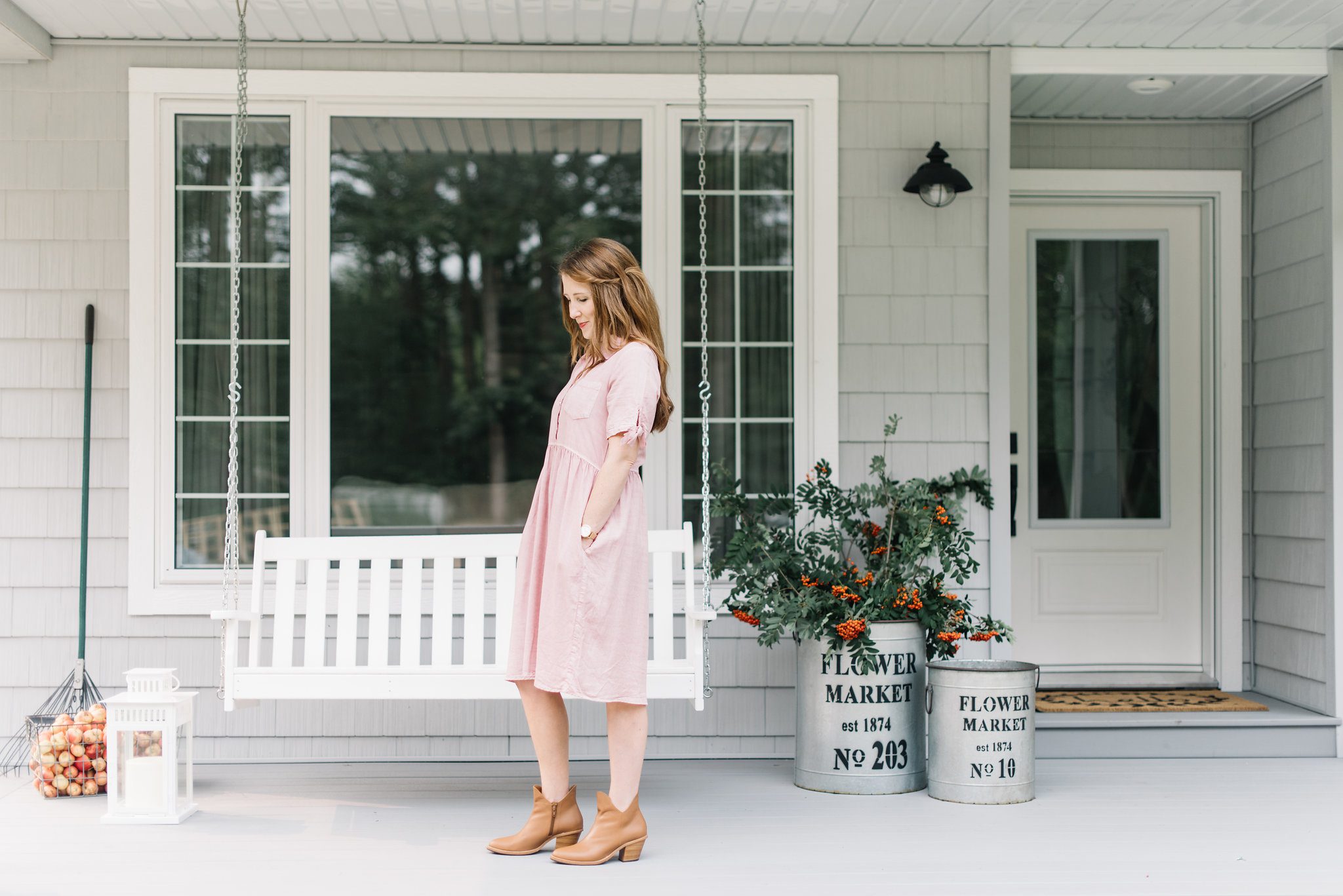 woman standing on front porch in a pink dress