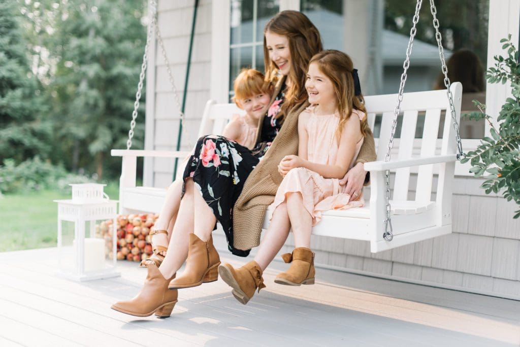 A woman sitting on a bench with little girls