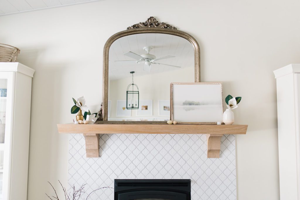 white oak fireplace mantle with a gold mirror