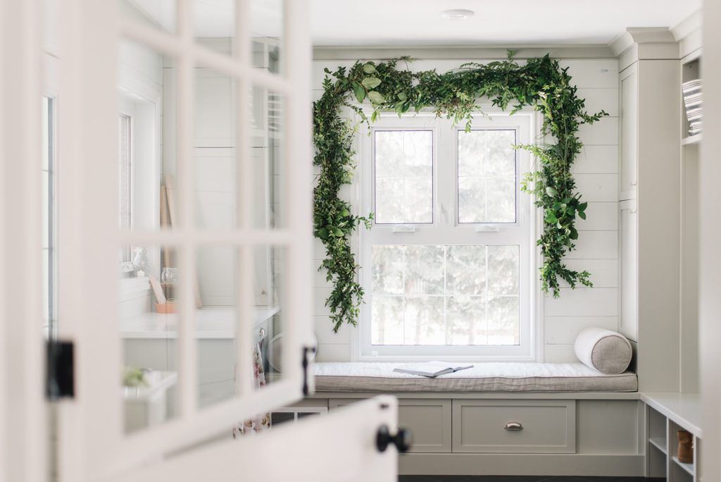  a fresh garland of greens hung above a large window