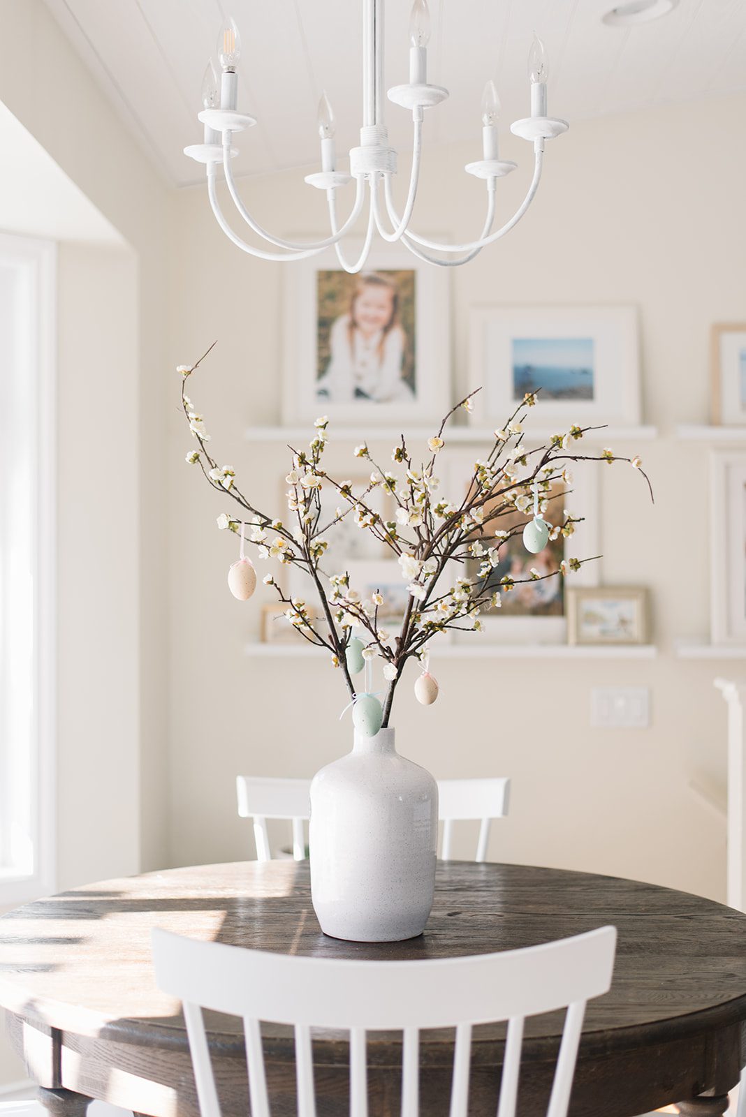 A vase of pussy willows with Easter eggs hung on the branches