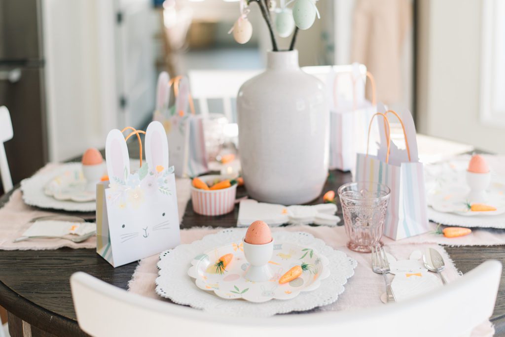 An Easter table set with pink, orange and white decorations
