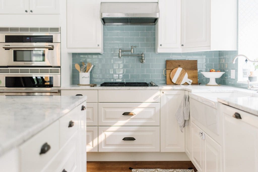 A white kitchen with blue backsplash tile