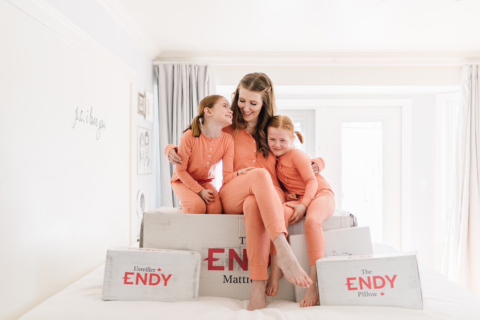 Woman and kids sit on an Endy bed in a box