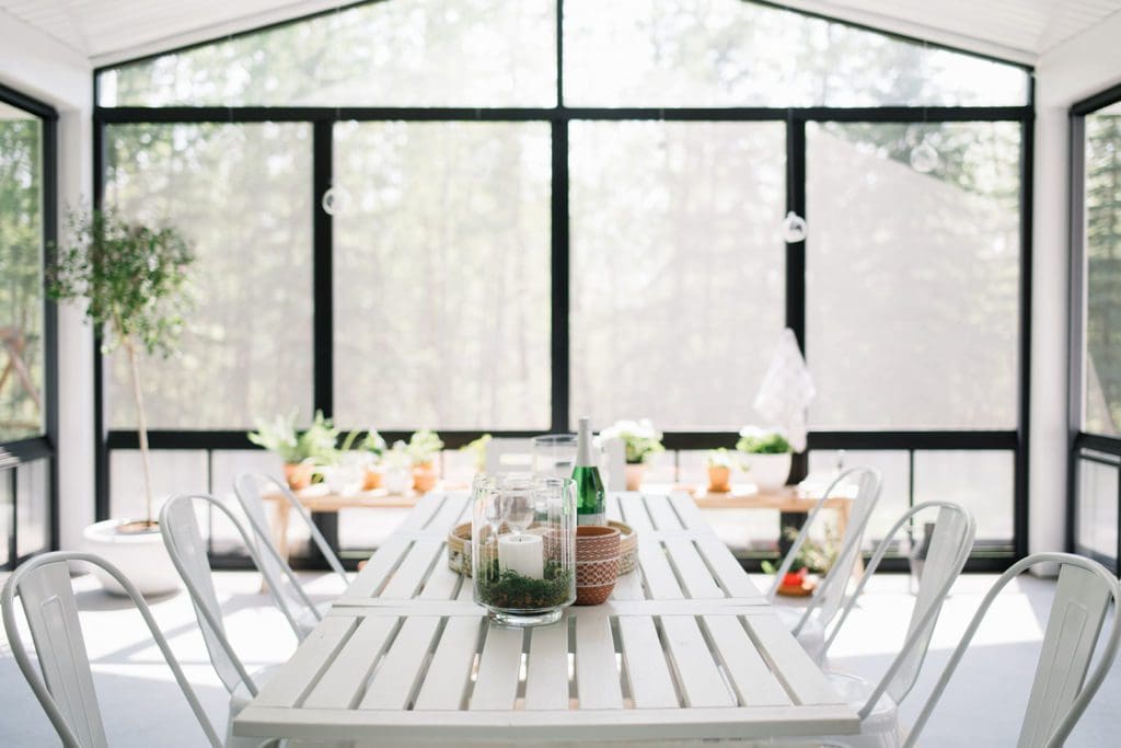 A vase of flowers on a table next to a window