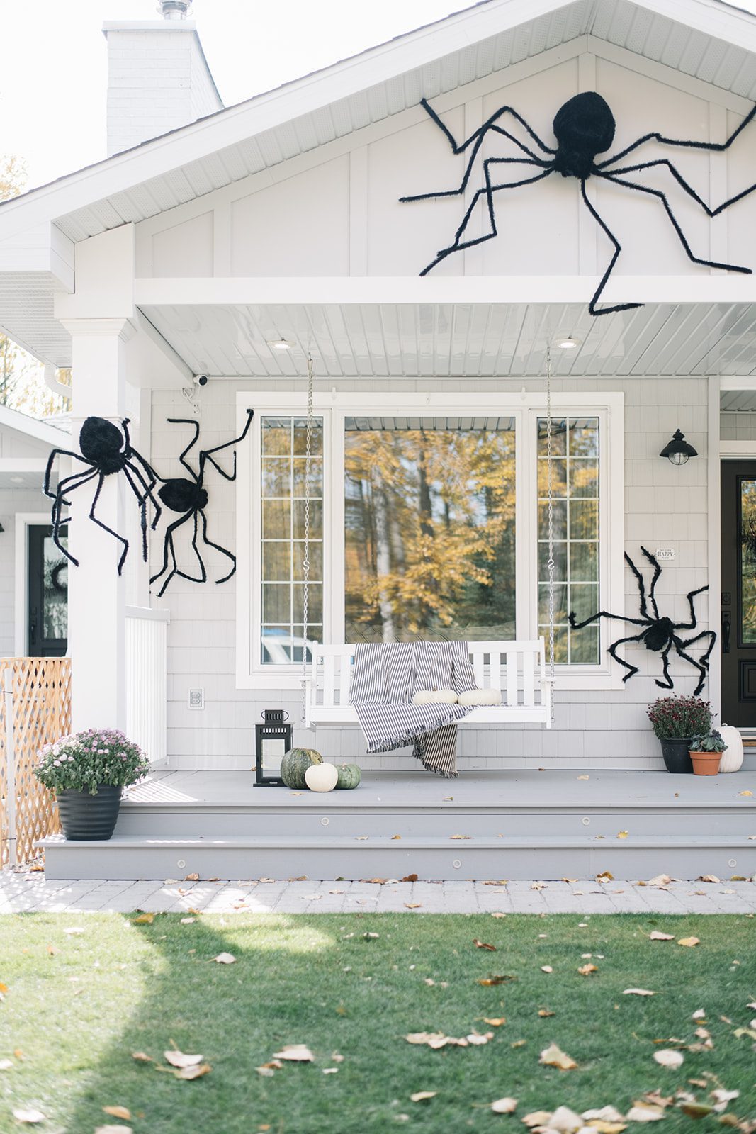 faux spiders attached to front porch pillars on house