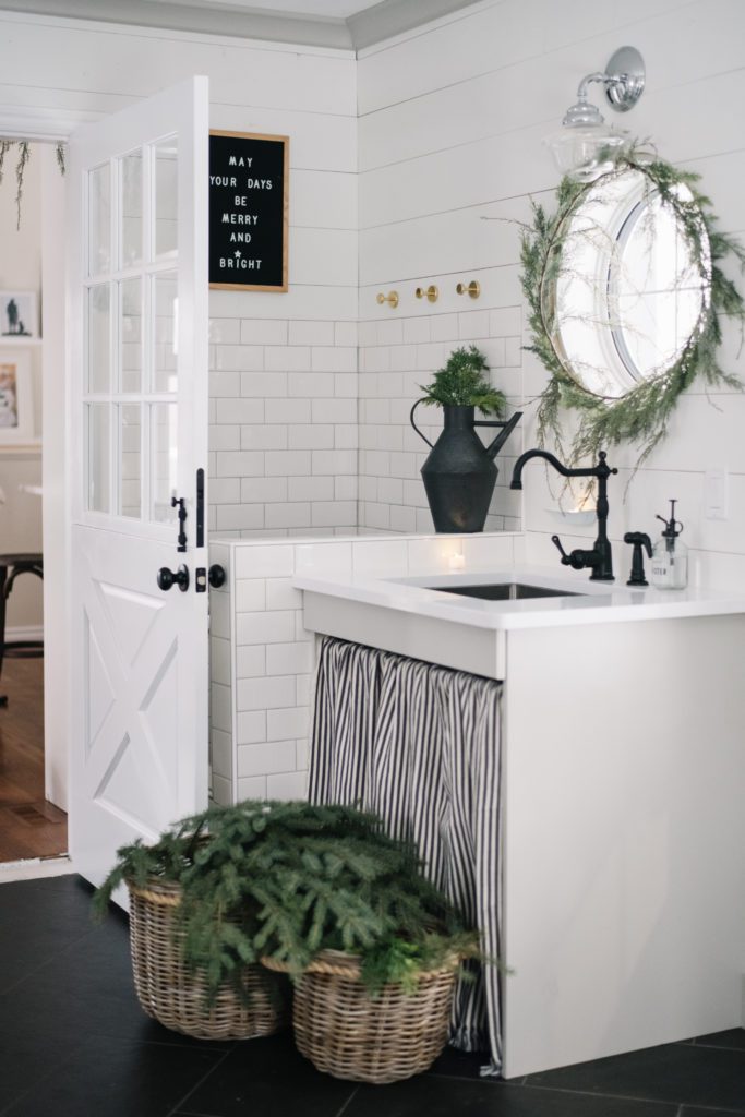 minimal holiday home decor  -a Christmas mudroom sink decorated with cedar garland