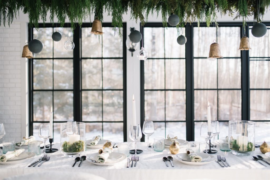 A modern country Christmas tablescape with hanging greenery and ornaments