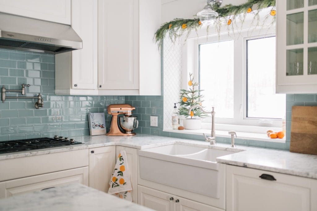 Dried oranges look hung above the kitchen window and on mini tree on kitchen window sill