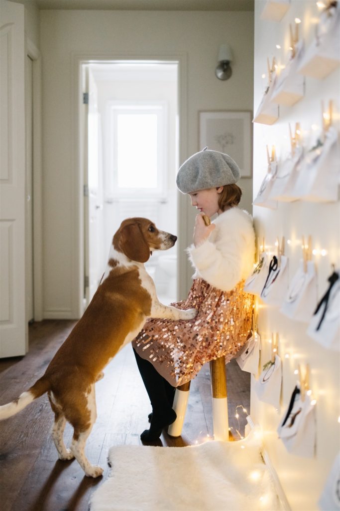 Little girl and dog sitting infant of christmas lights
