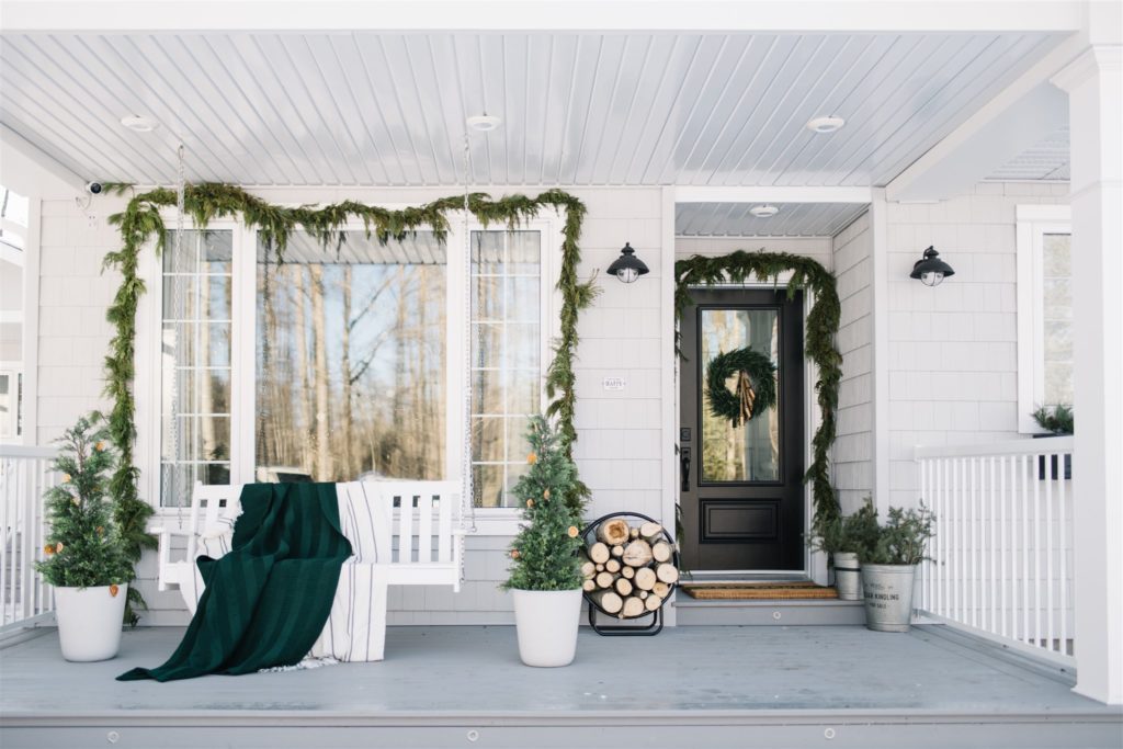 Scandinavian Christmas porch with fresh holiday garland 