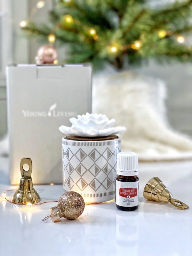 a ceramic flower-topped diffuser and a bottle of essential oil