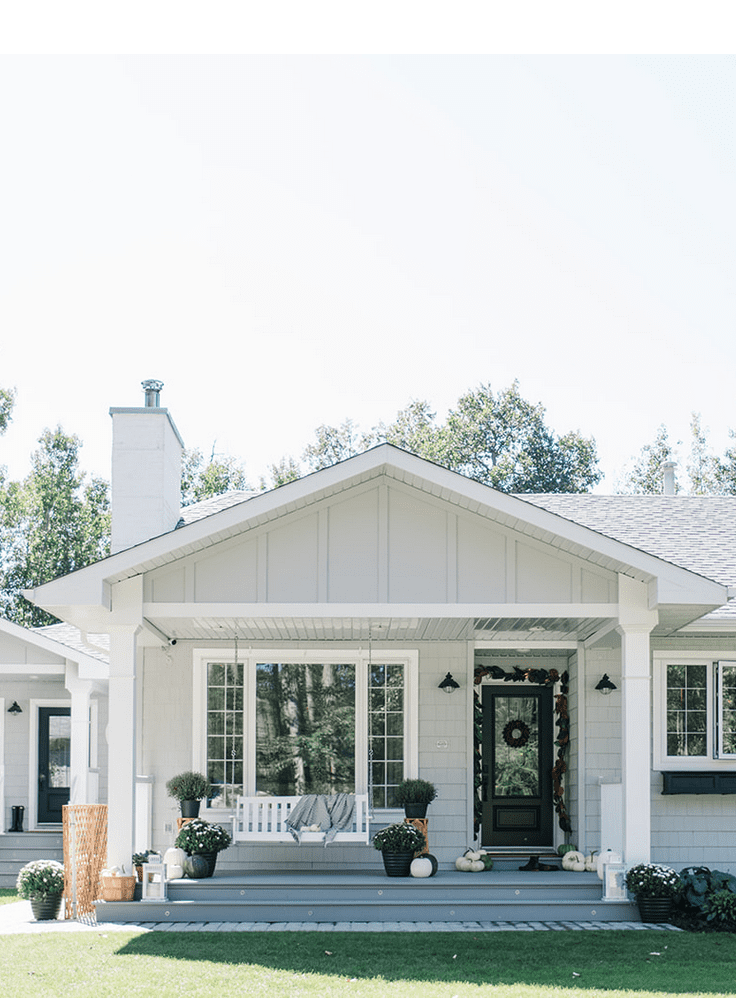 A grey farmhouse with white windows