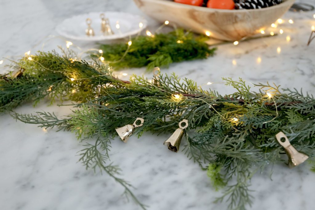 brass bell garland attached to faux greenery