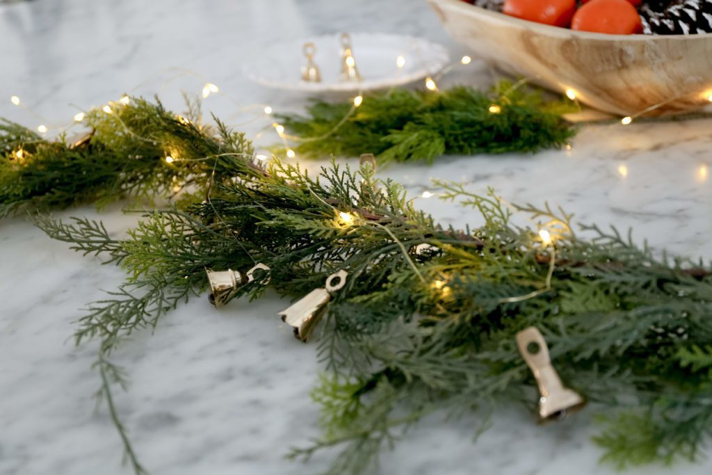 brass bells and twinkle lights with garland
