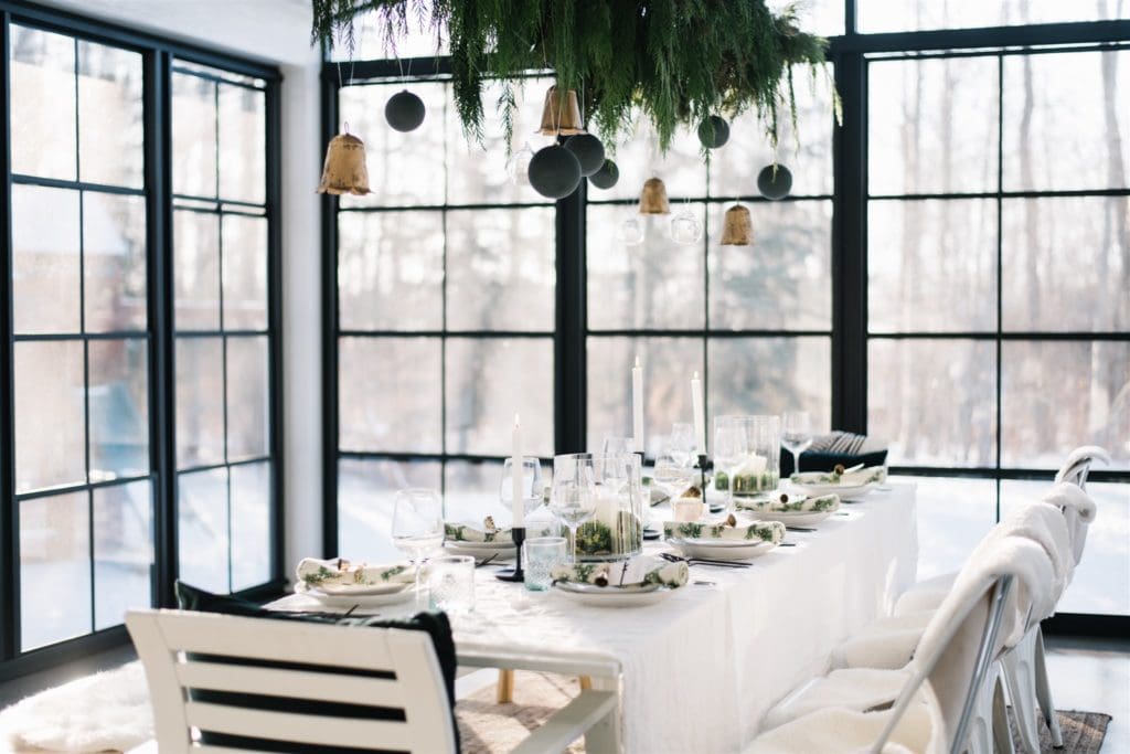 A minimal and modern country christmas table setting in a sunroom with black windows