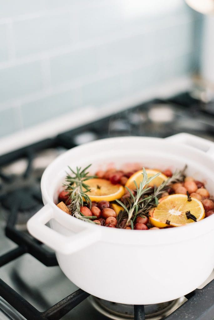 Simple holiday stovetop potpourri on the stove in a white pot