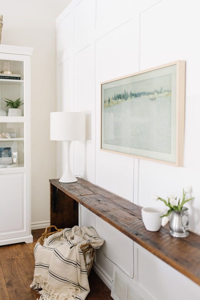 white oak framed TV above a wooden console table