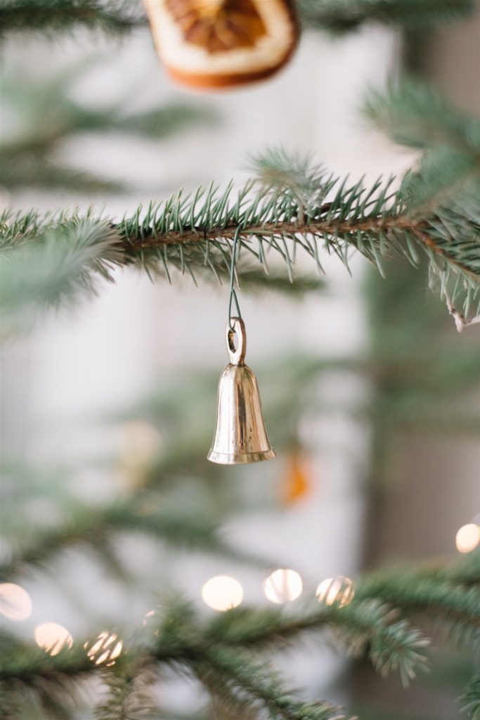 mini brass bell hung on a tree branch