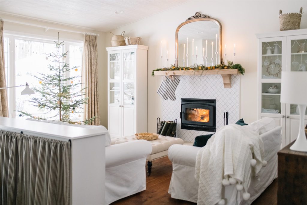 neutral living room with fire burning decorated for CHristmas