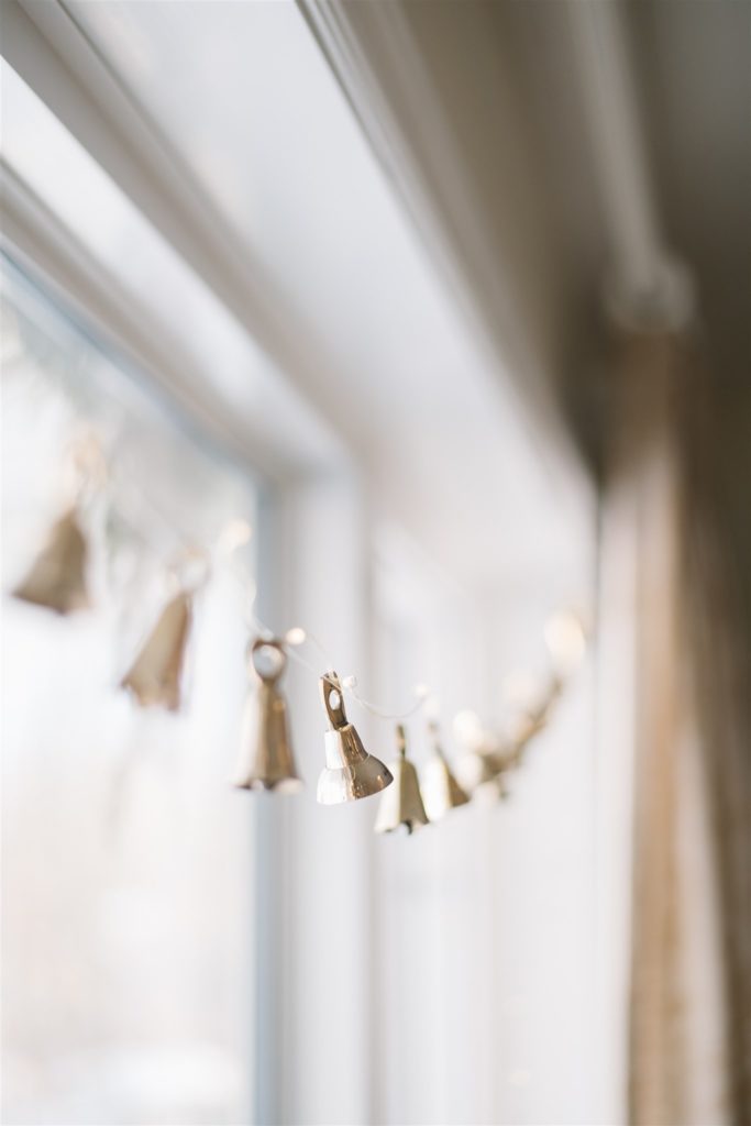 brass bell garlands hung in front of window