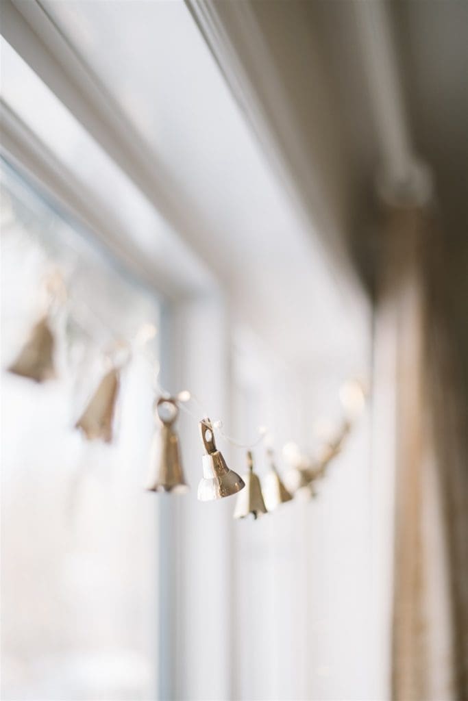 brass bell garlands hung in front of window