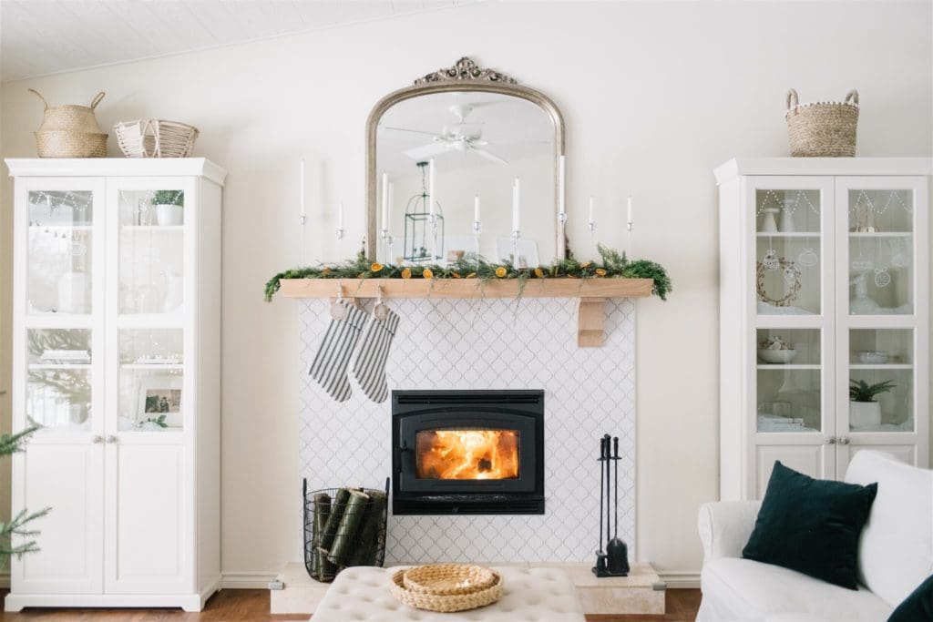 fireplace mantle with greens, dried oranges and striped stockings