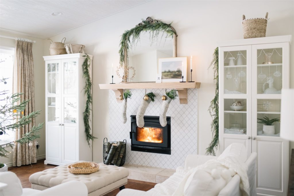 a neutral living room styled for christmas with stockings and greens