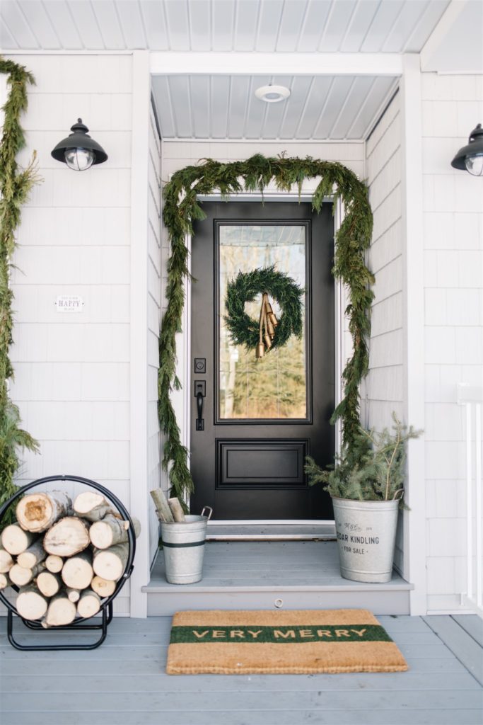 Neutral Scandinavian Christmas porch with fresh green garland