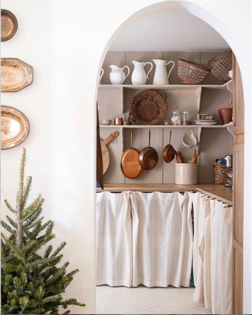 European style pantry with linen curtains and arched entryway