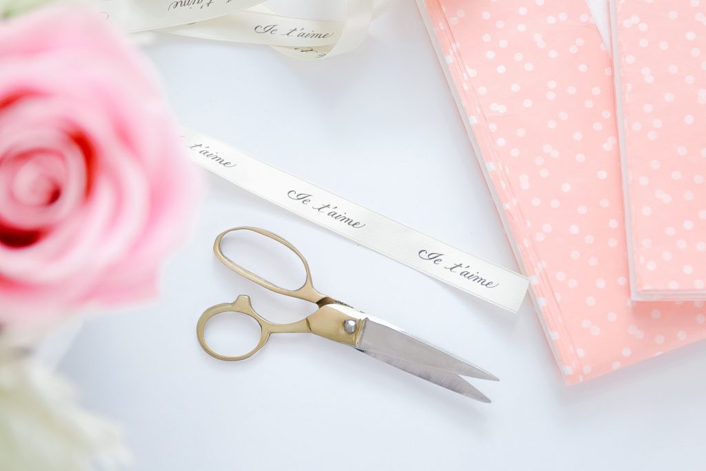A pair of scissors cutting ribbon