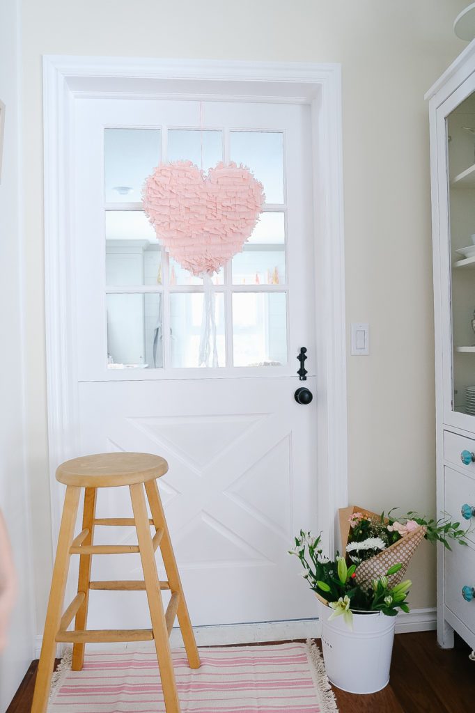 a pink heart pînata hung on a door
