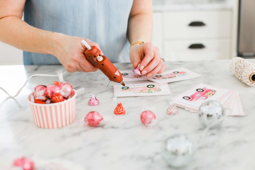 glueing candy onto wheels of cars on Valentine\'s day cards
