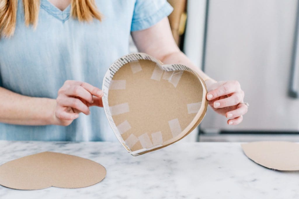 taping edge onto heart pinata