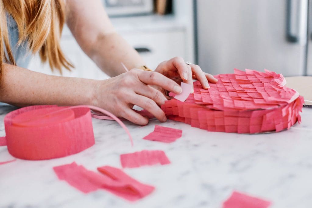 adding ribbon to bottom of heart pinata