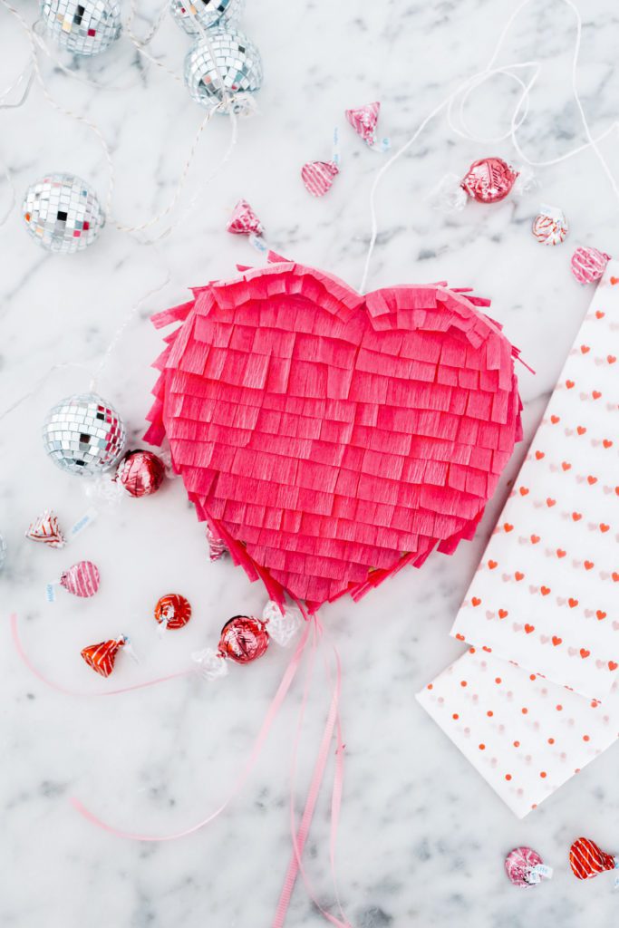 mini heart pinata and candies on marble counter